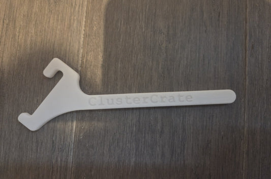 White angled spool mount on a wood surface, ClusterCrate name on the arm
