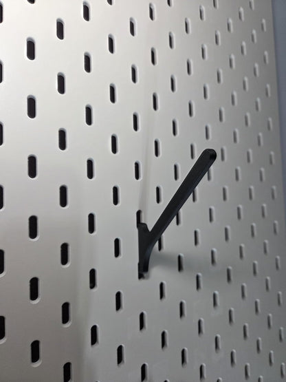 Black angled spool mount clipped into a white IKEA SKADIS pegboard